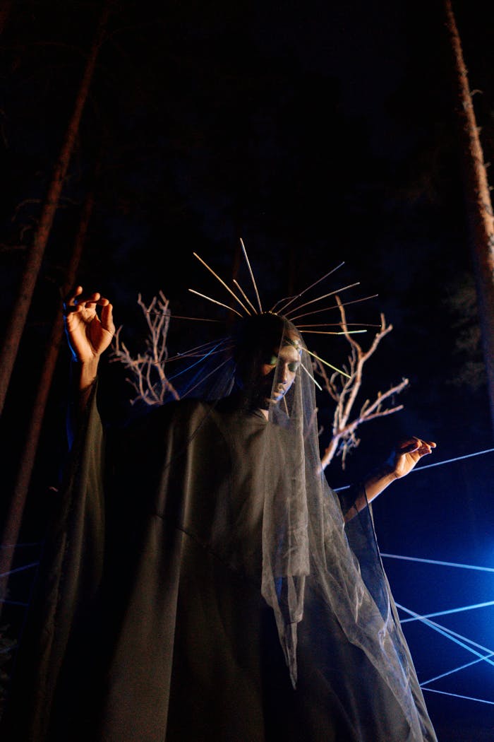 Services A mysterious figure dressed in black with a headdress, performing rituals at night in a forest.
